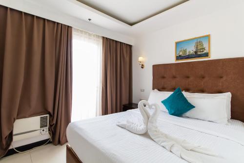 um quarto de hotel com uma cama e uma janela em Pacific Bay Grand Suites em Manila