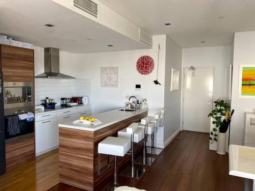 a kitchen with a counter and some chairs in a room at In the city Perth 1B1B Pool and nice view in Perth