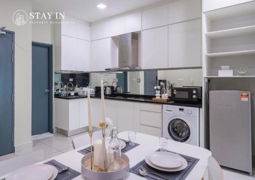 a kitchen with white cabinets and a dishwasher at Atria Sofo Suites - Petaling Jaya in Petaling Jaya