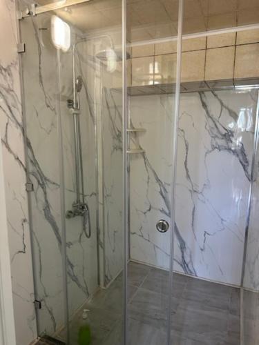 a shower with a glass door in a bathroom at Tunduk Hostel in Bishkek