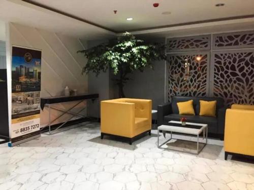 a lobby with yellow chairs and a couch and a table at Apartment Mont Blanc By Ilfal in Bekasi