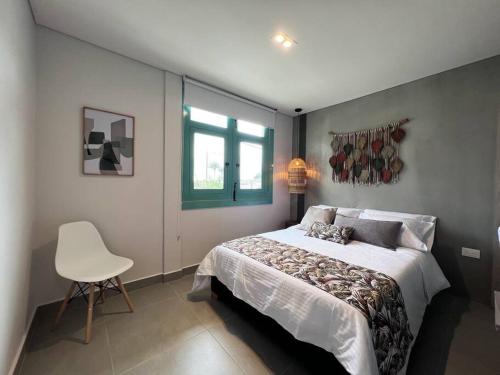 um quarto com uma cama, uma cadeira e uma janela em Parallelo loft Salento P5 em Salento