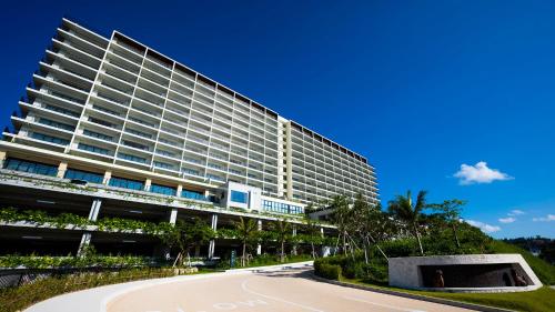 a large building with a road in front of it at Hiyori Ocean Resort Okinawa in Onna
