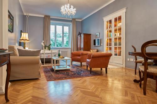 sala de estar con muebles y lámpara de araña. en Schieszl Apartments 2 en Budapest