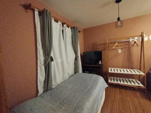 1 dormitorio con cama y ventana con cuna en Monoambiente lindo y luminoso en San Carlos de Bariloche