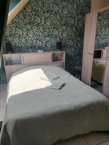 Le domaine d Estelle في Danestal: غرفة نوم بسرير كبير وبجدار اخضر
