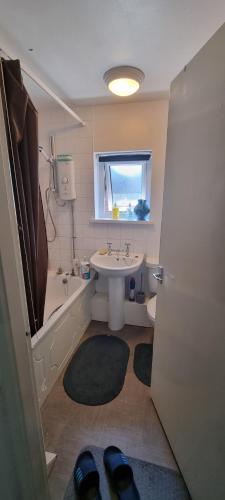 a bathroom with a sink and a tub and a toilet at Spacious Room with Kichenet in Greasbrough