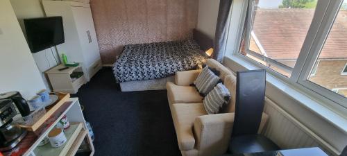 a small room with a couch and a bed at Spacious Room with Kichenet in Greasbrough