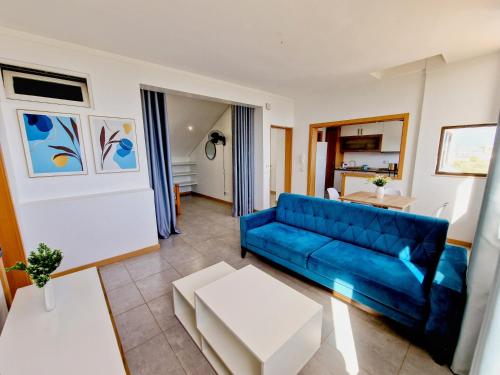 uma sala de estar com um sofá azul e uma mesa em Kelly Guest House em Praia