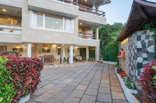 an exterior view of a house with a patio at Emilia Villa by VEO - Part of StayVista in Mahabaleshwar