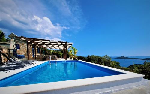 a swimming pool with a view of the water at Villa Robinson in Tkon