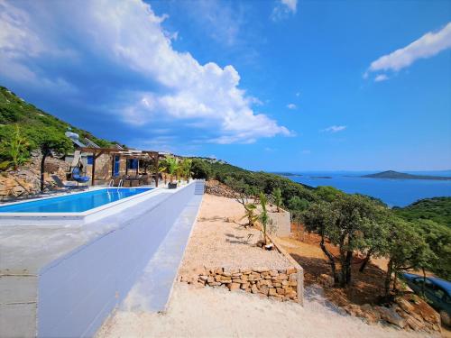 a villa with a swimming pool and a view of the ocean at Villa Robinson in Tkon