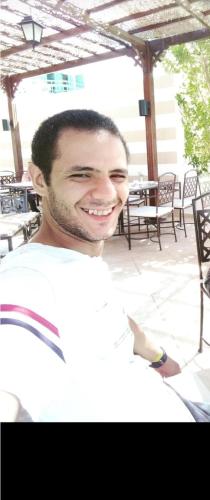 Ein Mann in einem weißen Hemd lächelt in der Unterkunft مصطفى كامل in Alexandria