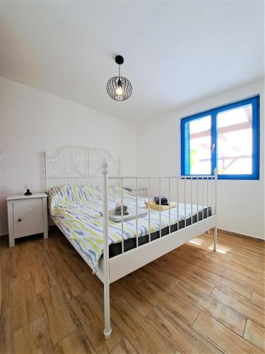 a white bed in a bedroom with a wooden floor at Villa Robinson in Tkon