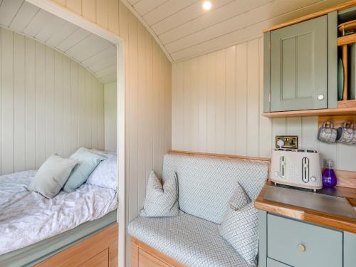 a small bedroom with a bed and a kitchen at Longwool Lookout in Hemingby