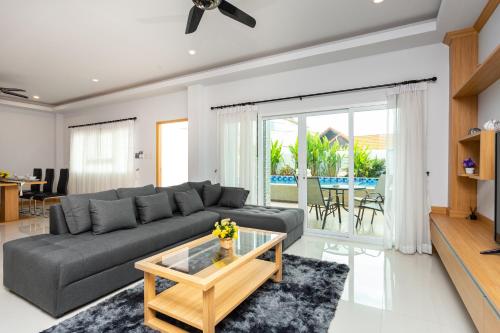 a living room with a gray couch and a glass coffee table at Relax Pool Villa Near Walking Street,jacuzzi ,BBQ 5Bed 6Bath City house54 in Pattaya South