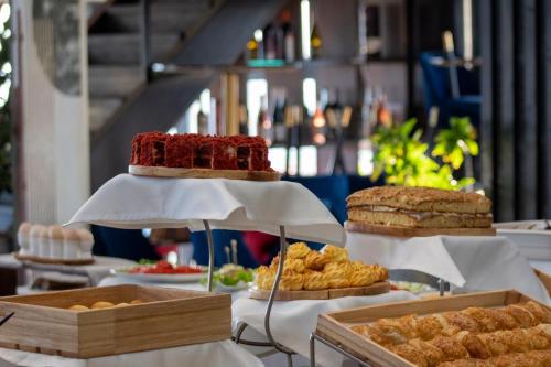 a table topped with different types of bread and pastries at Orient Hotel Bishkek in Bishkek