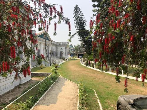 a car parked in front of a white house at COSSIMBAZAR PALACE OF THE ROYS ( RAJBARI) in Cossimbāzār