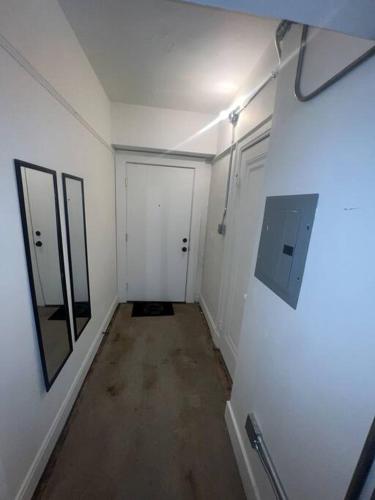 einen leeren Flur mit zwei weißen Türen und einem Spiegel in der Unterkunft 1 Bedroom Apartment Downtown in Detroit