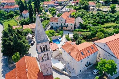 una vista aérea de una iglesia con techos naranjas en Luxury house David with heated pool, jacuzzi and sauna, en Nerežišće