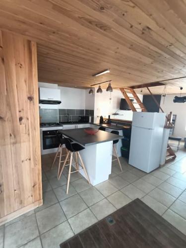 - une cuisine avec des plafonds en bois et une table dans une chambre dans l'établissement La Girouette, à Fumay