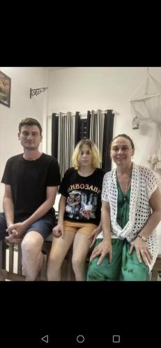 three people sitting on a bench in a room at CLIFF HEAVEN in Varkala