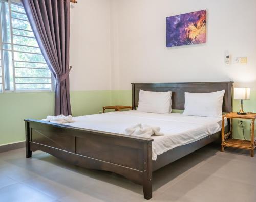 a bedroom with a bed in a room at Sanssouci Kep in Kep