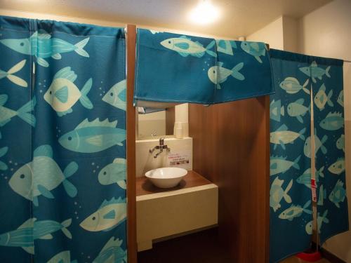 La salle de bains est pourvue d'un rideau de douche bleu et d'un lavabo. dans l'établissement SPA-RESORT Ryugunotukai - Vacation STAY 34897v, à Inatori