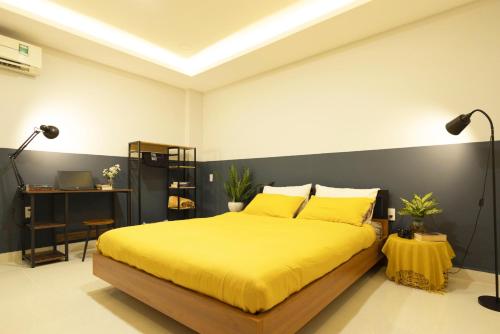 a bedroom with a yellow bed and a black wall at Karat Home in Ho Chi Minh City