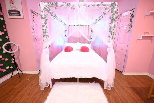 a pink bedroom with a bed with a canopy at Modern Luxury, Sleeps 5, Near Universities,Airport 15mins,Free Parking in Philadelphia