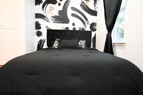 un letto nero in una camera da letto con parete in bianco e nero di Modern Luxury, Sleeps 5, Near Universities,Airport 15mins,Free Parking a Philadelphia