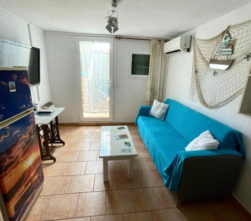 sala de estar con sofá azul y mesa en Apart Calan Forcat Menorca, en Cala en Forcat