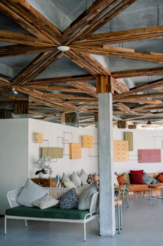 a living room with a green couch and wooden ceilings at Baleka Resort & Spa in Legian