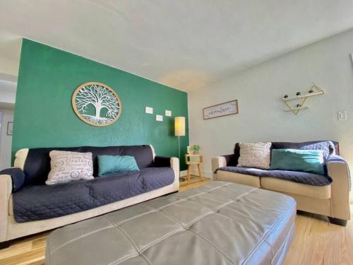 a living room with two couches and a green wall at Lively Home near Downtown, stadium, Wynwood in Miami