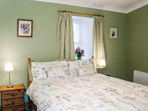 Schlafzimmer mit einem Bett mit grünen Wänden und einem Fenster in der Unterkunft The Bothy At Willowbank in Grantown on Spey