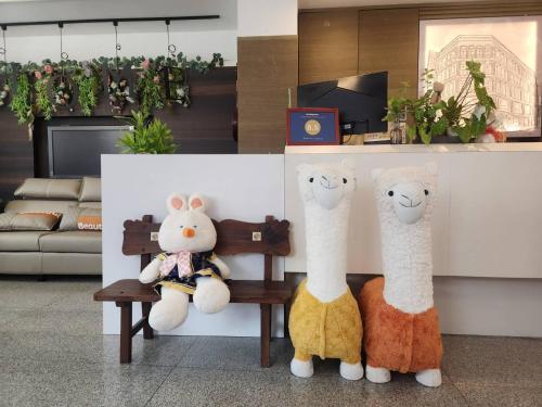 羅東鎮的住宿－家家商務旅館 Jia-Jia Business Hotel，两个塞满了东西的动物坐在一个房间里长凳上