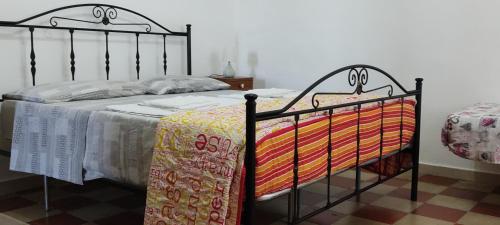 a bedroom with a black bed with a colorful blanket at Casa LOLU in Ortona