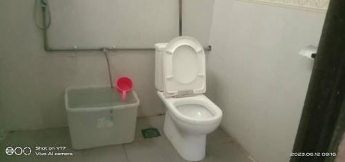 a bathroom with a toilet and a trash can at Mulu Helena Homestay in Mulu