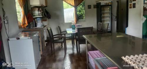 een keuken en eetkamer met een tafel en stoelen bij Mulu Helena Homestay in Mulu