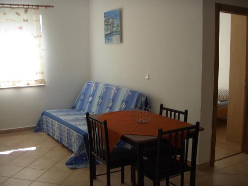 Una habitación con una mesa y una cama en una habitación en Apartments Ana, en Vir