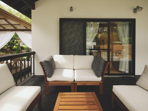 a living room with a white couch on a porch at Premium villa with stars and bonfire in Hokuto