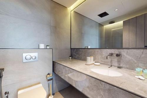 a bathroom with a sink and a large mirror at O Ten Al Jaddaf - Locations in Dubai