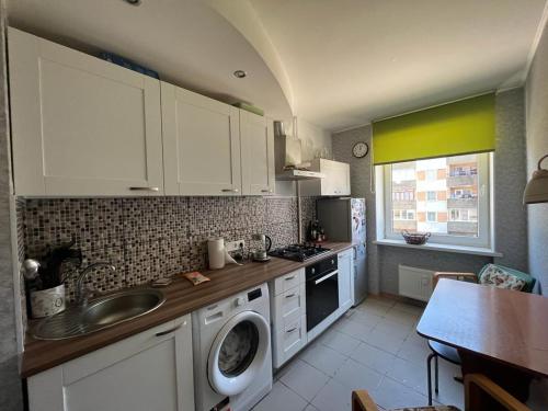 a kitchen with a sink and a washing machine at Atmodas 70 in Jelgava