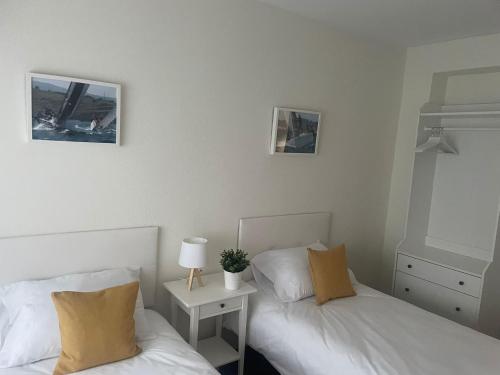 a bedroom with two beds and a night stand with a lamp at BegoÑa Suite in Gijón