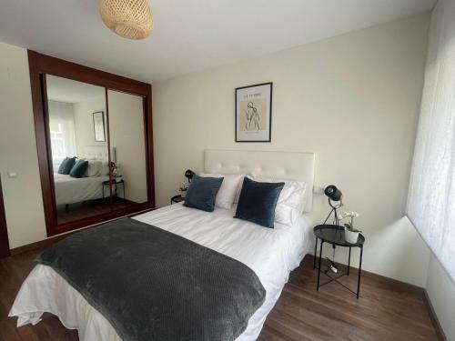 Un dormitorio con una cama grande y un espejo. en BegoÑa Suite, en Gijón