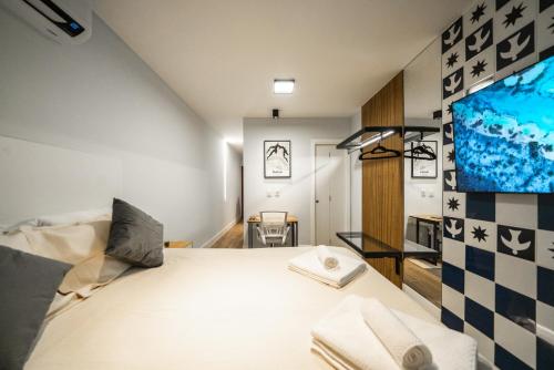 1 dormitorio con 1 cama y TV en la pared en Studio247 Experience by Haven en Brasilia