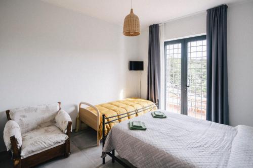 a bedroom with a bed and a couch and a window at Il Lampin B&B in Marina di Andora