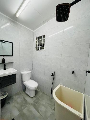 a bathroom with a toilet and a sink and a tub at Ruwa Homestay - 3BR, EV Port in Jitra
