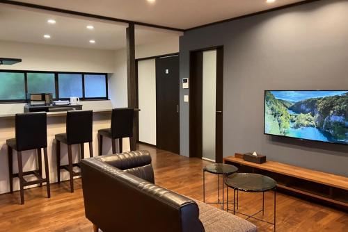 a living room with a large tv on the wall at 宮島 玖波宿 - GR Residence Kuba inn - 