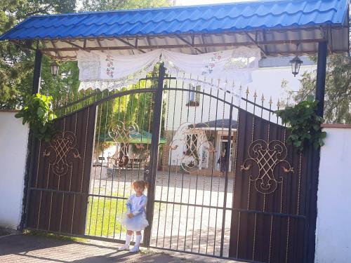 a little girl standing in front of a gate at La Banel Hotel in Selemet